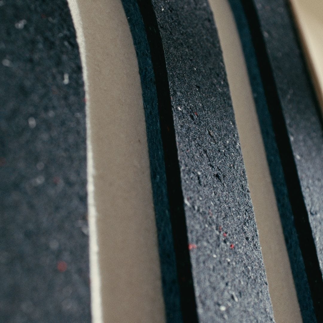 Close-up of eco-friendly acoustic panels in dark tones, crafted from sustainable materials with textured layers.